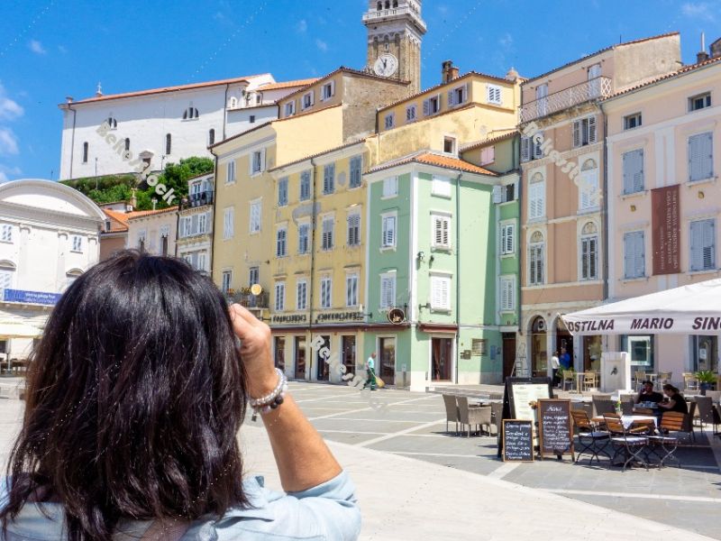Woman takes photos of Tartini Central Square in Piran. Piran, Ob Woman takes photos of Tartini Central Square in Piran. Piran, Ob