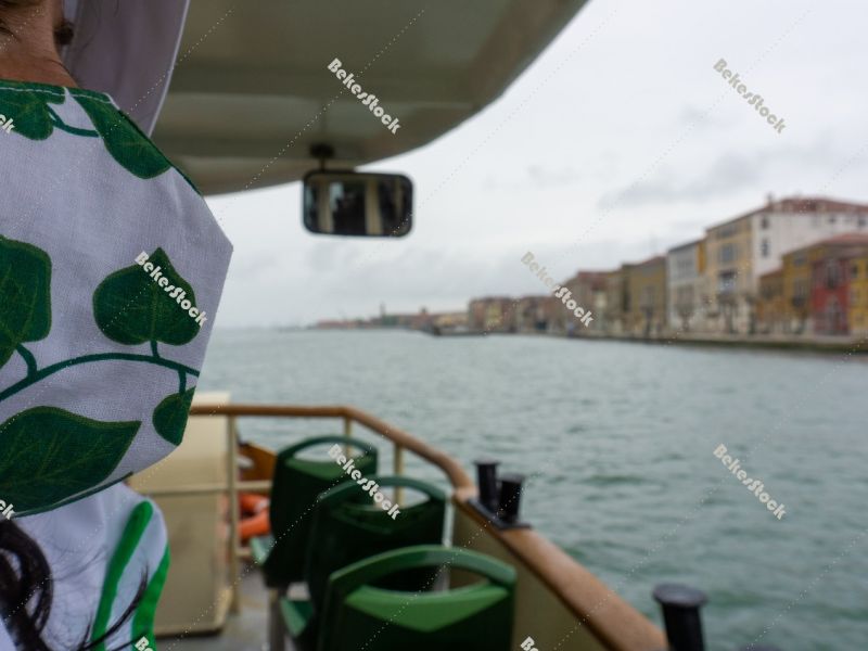 Woman in green patterned medical mask on the water bus. Venice,  Woman in green patterned medical mask on the water bus. Venice,