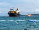 A pilot boat turn over a container vessel in port. Luka Koper (`