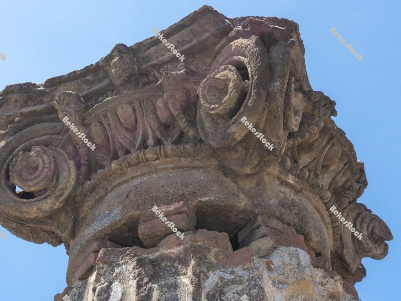Ancient Roman column capital (head) with blue sky in the backgro Ancient Roman column capital (head) with blue sky in the backgro
