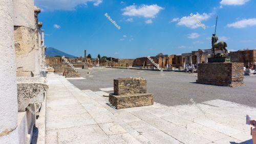 Civil Forum in Pompeii. The blue sky and Mount Vesuvius provide Civil Forum in Pompeii. The blue sky and Mount Vesuvius provide